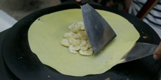 在越南夜市，小贩用香蕉煎薄饼。亚洲的街头食品。4 k