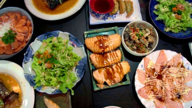 桌上有三文鱼、三文鱼烧和烤鸡。俯视图的食物。