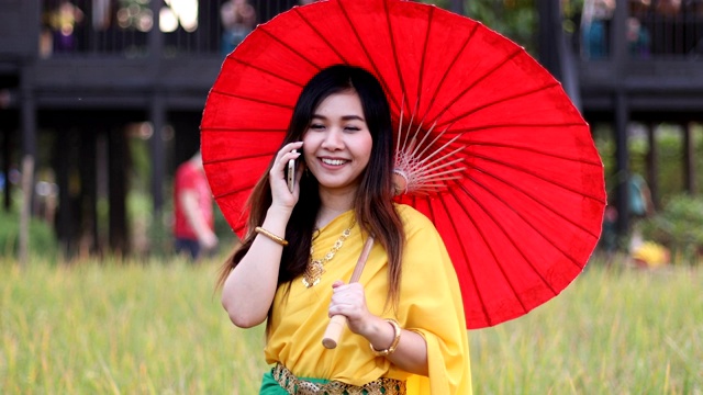 泰国妇女穿着传统风格拿手机