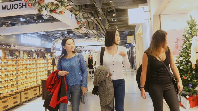 一群年轻的亚洲女性走过购物中心