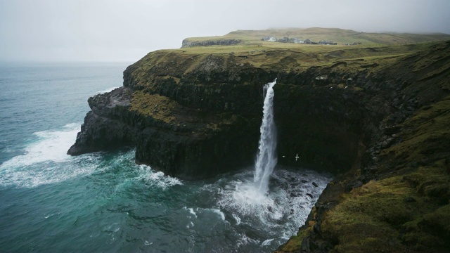 在法罗群岛的风景Múlafossur瀑布坠入大海