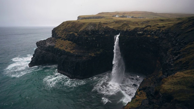 在法罗群岛的风景Múlafossur瀑布坠入大海