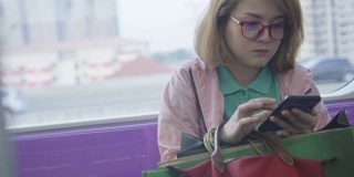 年轻女子在乘坐地铁时使用智能手机，慢镜头