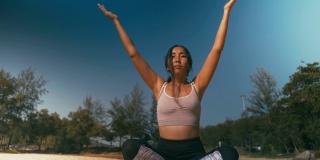 亚洲妇女在海滩上练习瑜伽健身运动。健康的生活方式
