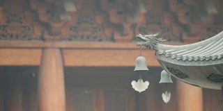 上海静安寺建筑屋檐上的神仙和野兽，御黄屋顶装饰，屋檐下的风铃随风摇摆，4K视频，慢镜头。