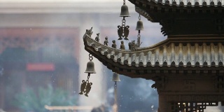 上海静安寺建筑屋檐上的神仙和野兽，御黄屋顶装饰，屋檐下的风铃随风摇摆，高速录像，慢镜头。