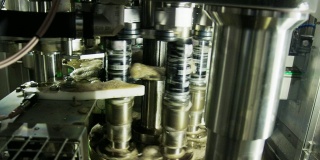 旋转装罐机通过在室内制造设施中旋转铝罐来密封铝罐
