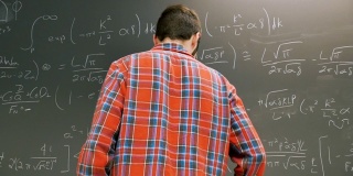 年轻的男大学生在拍黑板上的一道数学题
