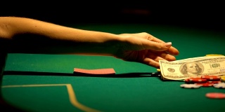 女人怀疑但把钱放在牌桌上，希望赢，赌运气
