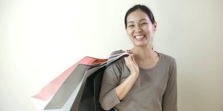 年轻快乐的亚洲女孩拿着很多购物袋