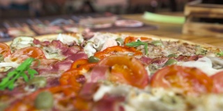 餐厅桌上的热披萨配西红柿和培根。正宗的意大利披萨，配上番茄、奶酪、橄榄。传统意大利美食，美食理念