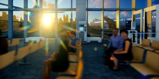 乘客在机场航站楼与飞机和城市天际线对着美丽的日出，平移