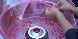手持机器制作粉色棉花糖。