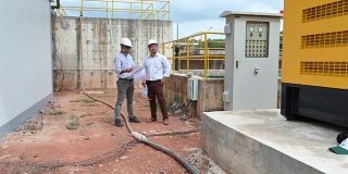 两位东南亚工程师在工地上讨论图纸