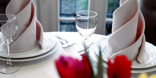 豪华餐厅里装饰精美的宴会桌。鲜花郁金香作为一个美丽的餐桌装饰在餐厅