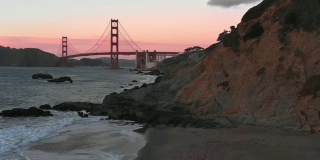 Slow Motion Aerial Video - Baker's Beach in San Francisco, California View of Golden Gate Bridge at Sunset