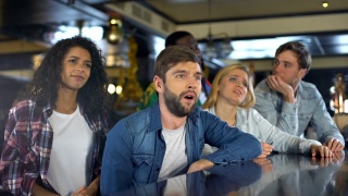 球迷挥舞着葡萄牙国旗，在酒吧里看体育比赛，为输掉比赛而难过视频素材模板下载