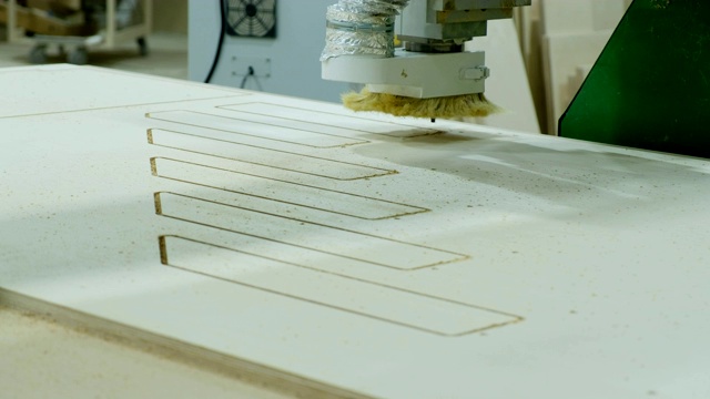现代木工机器在工作。从胶合板上切下卷曲的部分。木制家具生产