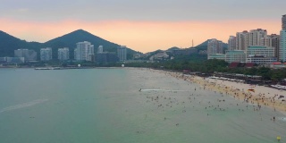 日落天空三亚著名的大东海拥挤的海滩航拍全景4k海南中国