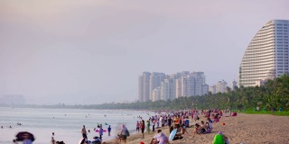 日落光线三亚拥挤的海滩海岸线全景4k时间推移海南岛中国