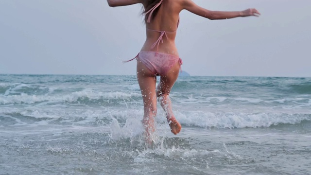 少女在沙滩上跳跃，奔跑，享受。的生活方式。自由。旅行。假期——iStock
