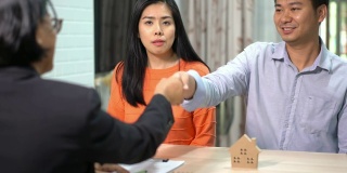 女人在文件上签字合同房地产购买和握手成功的商业合同交易销售代表。