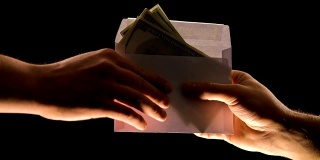手给信封里的钱孤立黑钱，贪污或非法工资