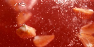 成熟的草莓片漂浮在果汁中