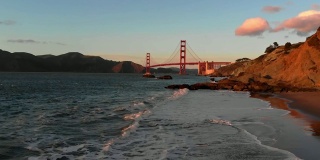 慢动作航空视频-贝克的海滩在旧金山，加州的金门大桥日落