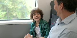 可爱的儿子和他的父亲说话，让他在火车上的通勤大笑