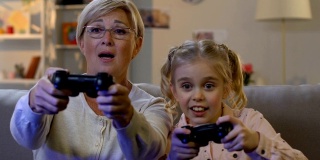 可爱的女孩和奶奶一起玩电子游戏，展示青春娱乐