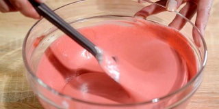 特写，用抹刀搅拌粉色浆果慕斯。