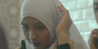 穿着民族服装的穆斯林妇女正在调整她的头巾