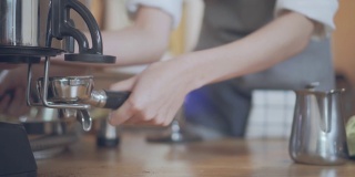 咖啡师用咖啡机磨咖啡豆。