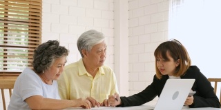 亚洲资深夫妇在家里得到理财规划师的建议。老在家里。