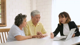 亚洲资深夫妇在家里得到理财规划师的建议。老在家里。视频素材模板下载