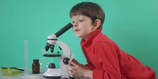 小男孩在用显微镜做生物化学研究