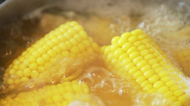 鲜亮多汁的黄色玉米的质地，在炉子上的沸水中煮沸。美味的年轻甜玉米。富含维生素的夏季健康蔬菜。宏