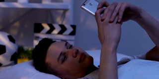 青少年用手机发短信，躺在床上，和女朋友聊天，约会网站