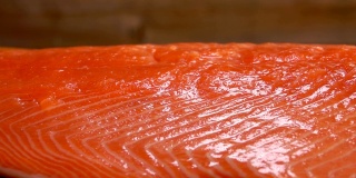 盐撒在生鲑鱼片上的特写