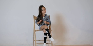 可爱的小女孩在照相馆摆姿势。