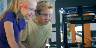 A boy and a girl are excited about the course of a technological experiment