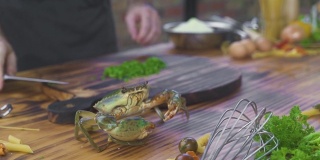 在海鲜餐厅做饭的时候，海蟹爬在桌子上。厨师带着海蟹在海鲜餐厅做菜。法国菜的新鲜原料。奢侈的美味佳肴