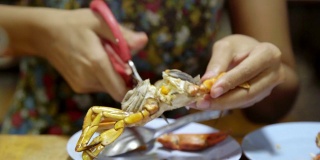 亚洲女人吃螃蟹海鲜烧烤。