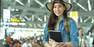在候机楼的年轻女人的肖像。年轻妇女独自乘飞机旅行。