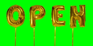 绿色屏幕上漂浮着金色氦气气球上的字母