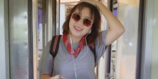 一名亚洲女子在坐火车时边走边找座位。