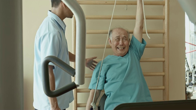 中国老人在理疗室拉绳子和做鬼脸的实时视频