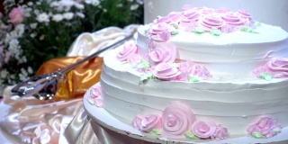 镜头:美丽的婚礼蛋糕，在婚宴上装饰着鲜花。