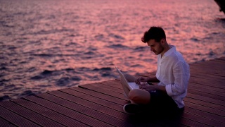 男博主在海边写文章视频素材模板下载